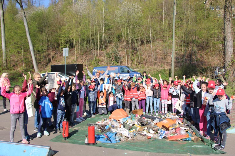 Gruppe von Jugendlichen vor gesammeltem Müll