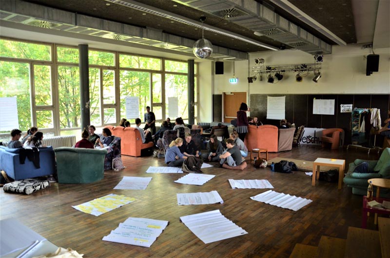 Studierende in einem Workshop mit Plakaten auf dem Boden