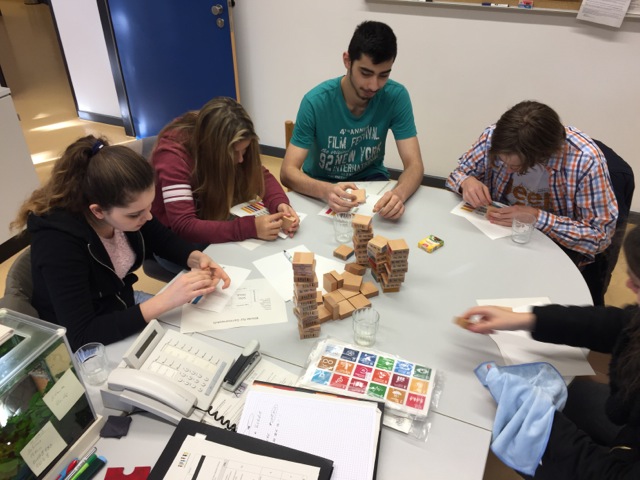 Gruppe Jugendlicher produziert Klötze mit SDG-Symbolen