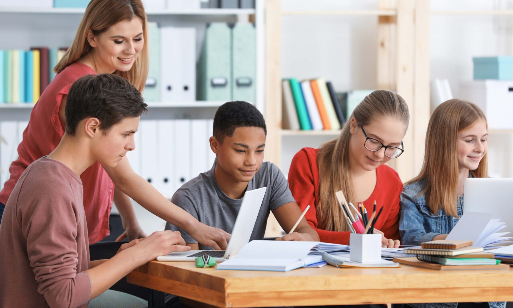 Lehrerin mit Schülergruppe am Laptop