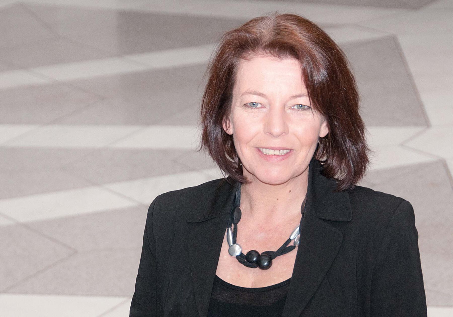 Frau im schwarzen Blazer lächelt