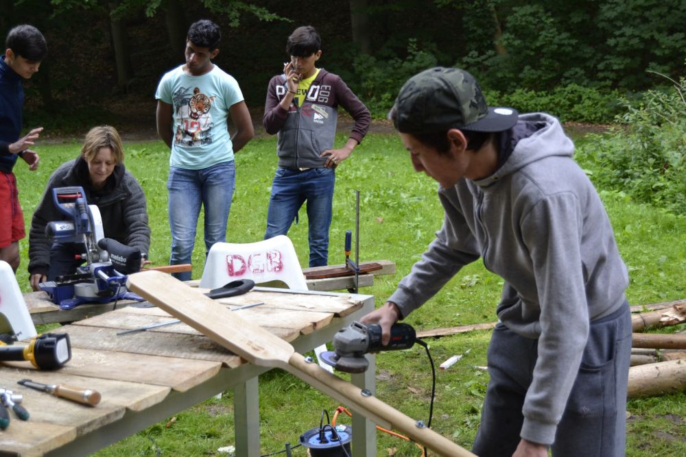 mehrere Jugendliche beim Bau eines Paddels aus Holz