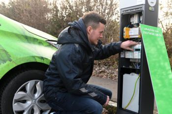 Mann an Ladesäule für Elektrofahrzeuge