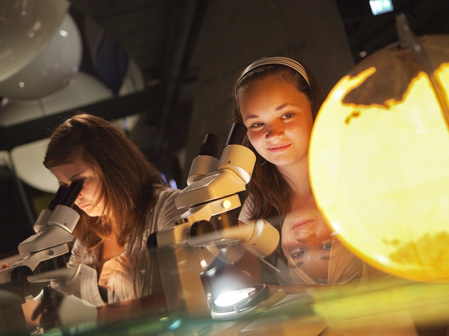 Mädchen arbeiten an Mikroskopen