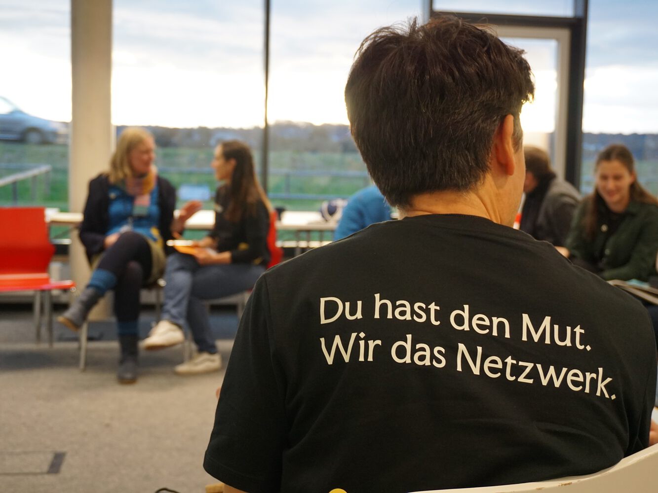 Mehrere Personen sitzen in einem Workshop und diskutieren.