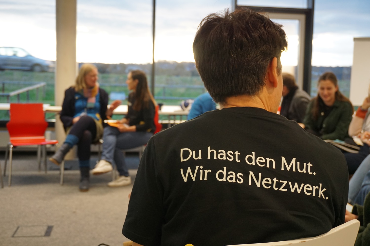 Mehrere Personen sitzen in einem Workshop und diskutieren.