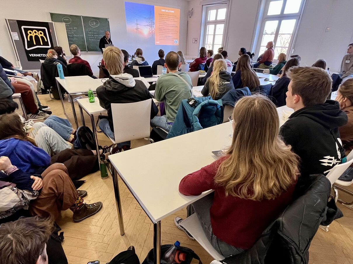 Vortrag vor einer Gruppe von Schülerinnen und Schülern in einem Klassenraum.